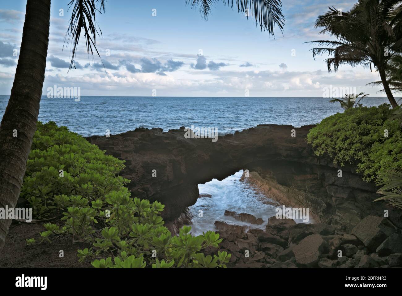 El Océano Pacífico se apresura en este arco de lava natural a lo largo de la costa de Puna en la Isla Grande de Hawai. Foto de stock