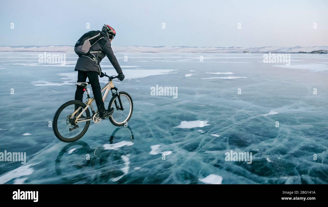 El hombre está montando en bicicleta sobre el hielo. Hielo del lago  congelado Baikal. T Fotografía de stock - Alamy