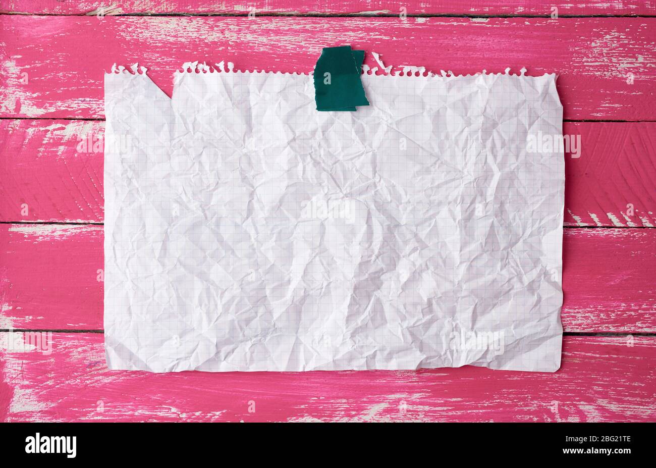 pegado con cinta adhesiva rectangular vacía blanco arrugado hoja de papel  sobre un fondo de madera rosa, lugar para la inscripción Fotografía de  stock - Alamy