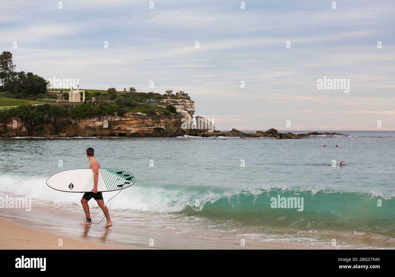 Sídney. 20 de abril de 2020. Un surfista camina en Coogee Beach en Sydney, Australia el 20 de abril de 2020. Los lugareños se bañan en el agua por primera vez en tres semanas, ya que las tres playas de Sydney se abren por primera vez desde que se desaceleró la propagación del COVID-19. Crédito: Bai Xuefei/Xinhua/Alamy Live News Foto de stock