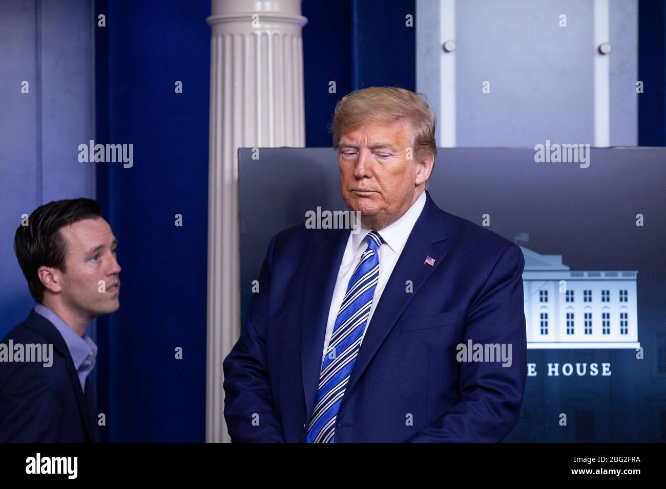 El presidente de Estados Unidos Donald J. Trump escucha durante una conferencia de prensa en la sala de información de prensa de James S. Brady en la Casa Blanca en Washington, DC, EE.UU., el domingo 19 de abril de 2020. La oradora de la Cámara de representantes de los Estados Unidos, Nancy Pelosi (demócrata de California), declaró que los legisladores están cerca de un acuerdo con el Secretario del Tesoro de los Estados Unidos, Steven T. Mnuchin, sobre una segunda ronda de préstamos para pequeñas empresas para empresas afectadas por el Coronavirus. Crédito: Stefani Reynolds/CNP /MediaPunch Foto de stock