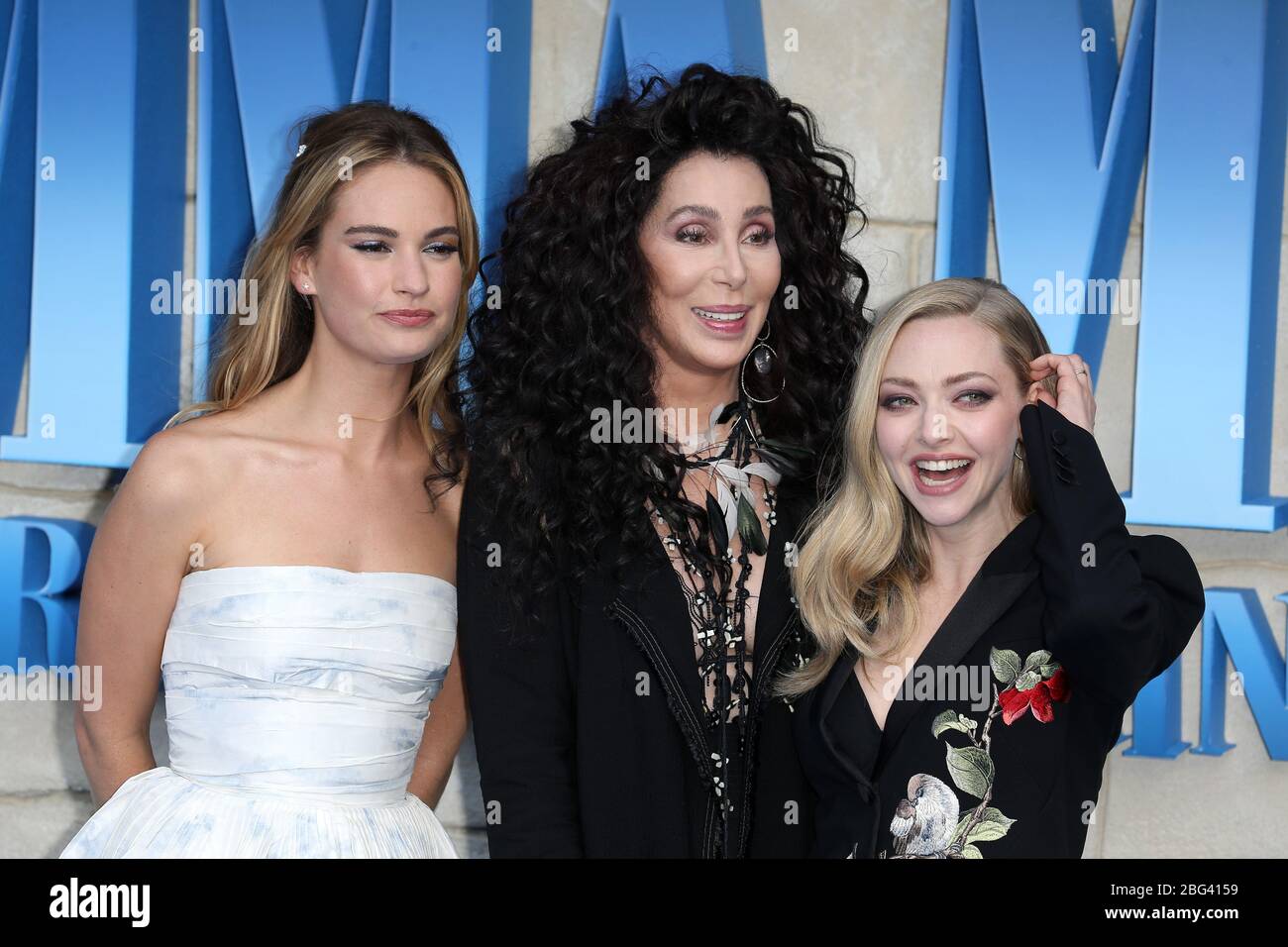 Lily James, Cher y Amanda Seyfried asisten al estreno británico de 'Mamma Mia! Aquí vamos de nuevo' en Eventim Apollo el 16 de julio de 2018 en Londres, Reino Unido. Foto de stock