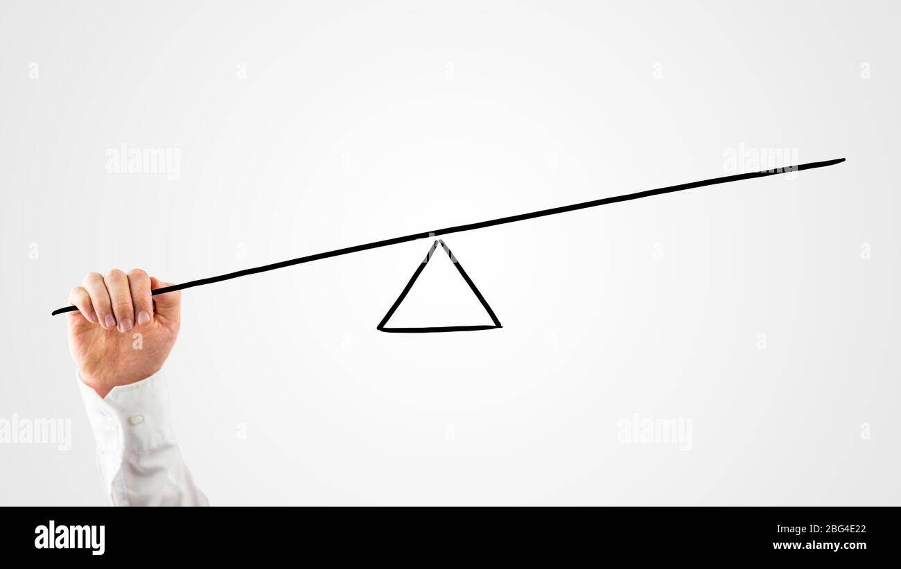 Hombre construyendo una zarapada con una vara y un triángulo en una interfaz virtual para pesar el equilibrio entre varios conceptos y ver que lleva el mo Foto de stock