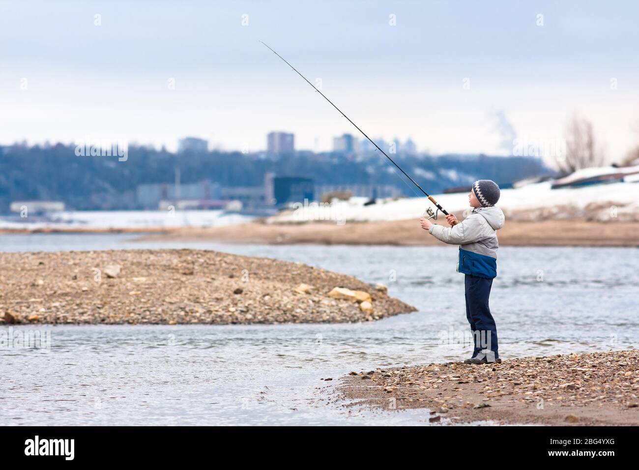 Hombre En La Orilla Del Río Arroja Una Barra Giratoria. Pesca