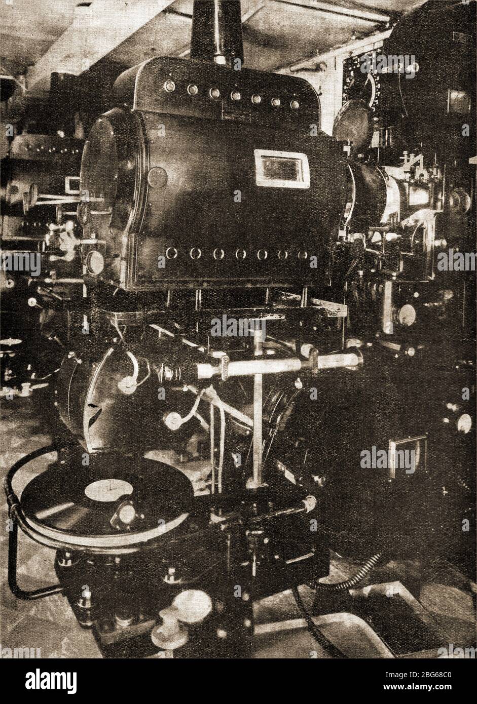 Una imagen de 1931 de un "proyector de cine parlante" británico y otros  aparatos, incluido un gran reproductor de grabación de sonido en disco que  proporcionó la banda sonora. En los años