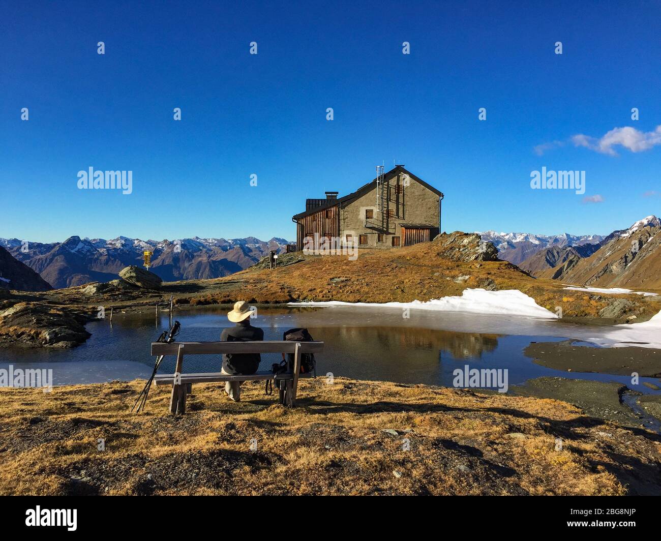 Excursionista descansando en la choza de Sudetendeutsche, refugio en lo alto de los alpes sobre Matrei en Osttirol, Tirol del este, Austria, a finales de otoño Foto de stock
