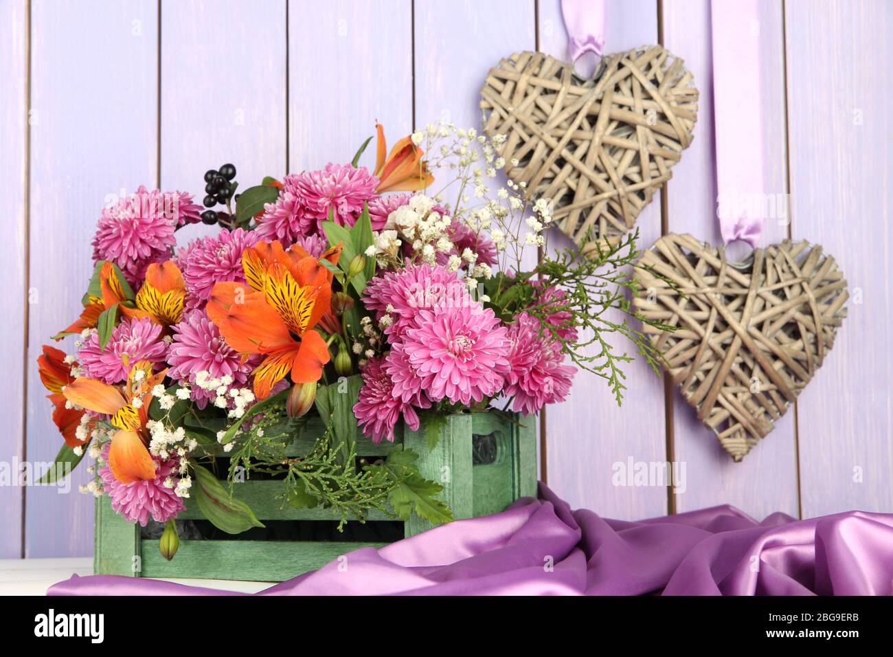 Composición de flores en caja con corazones decorativos sobre mesa sobre  fondo de madera Fotografía de stock - Alamy