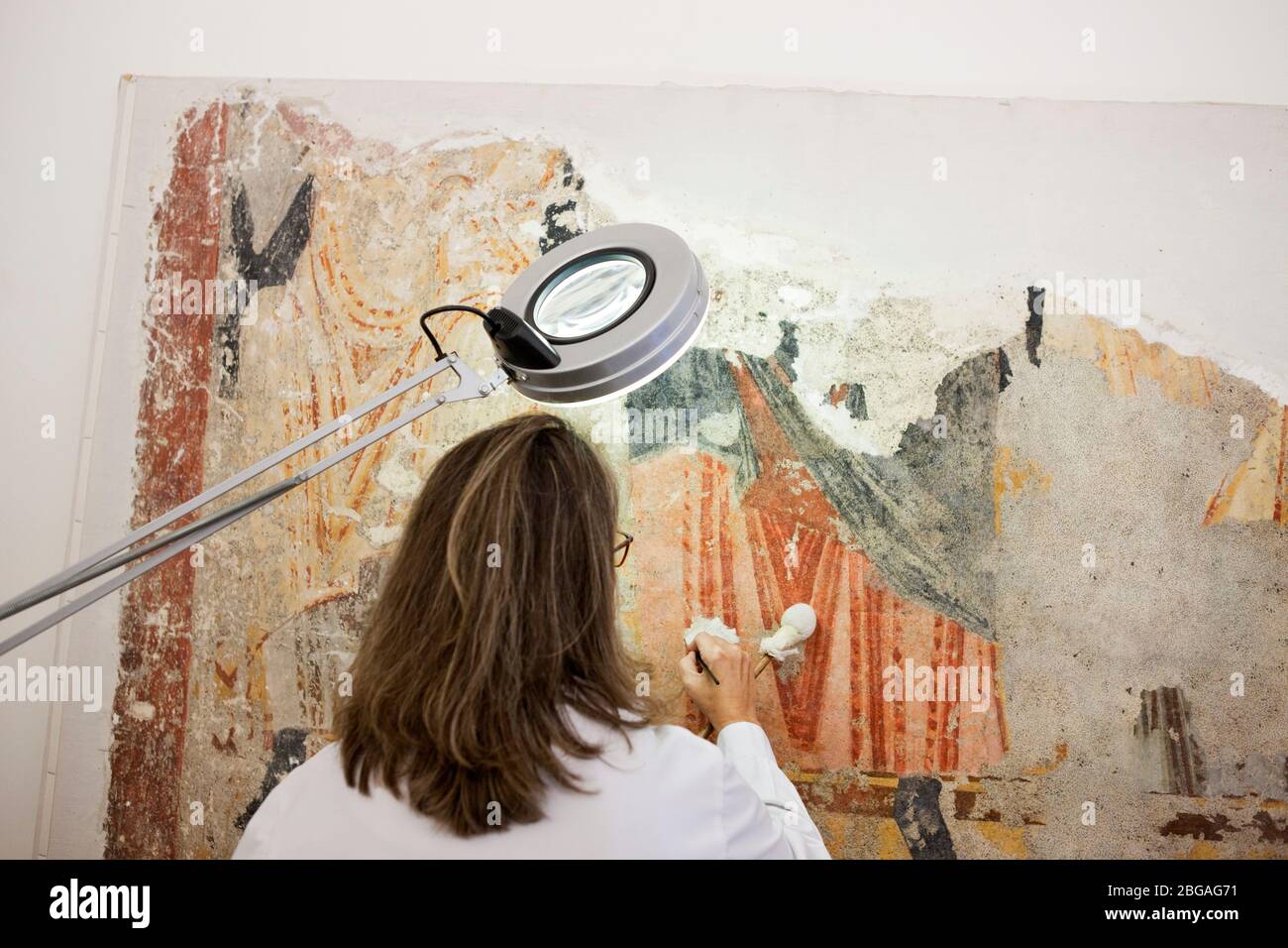 Paz Marqus, conservadora-restauradora de lÕËrea, especializada en pintura mural, treballant en un fragmento de pintura mural romˆnica arrenada i trasp Foto de stock