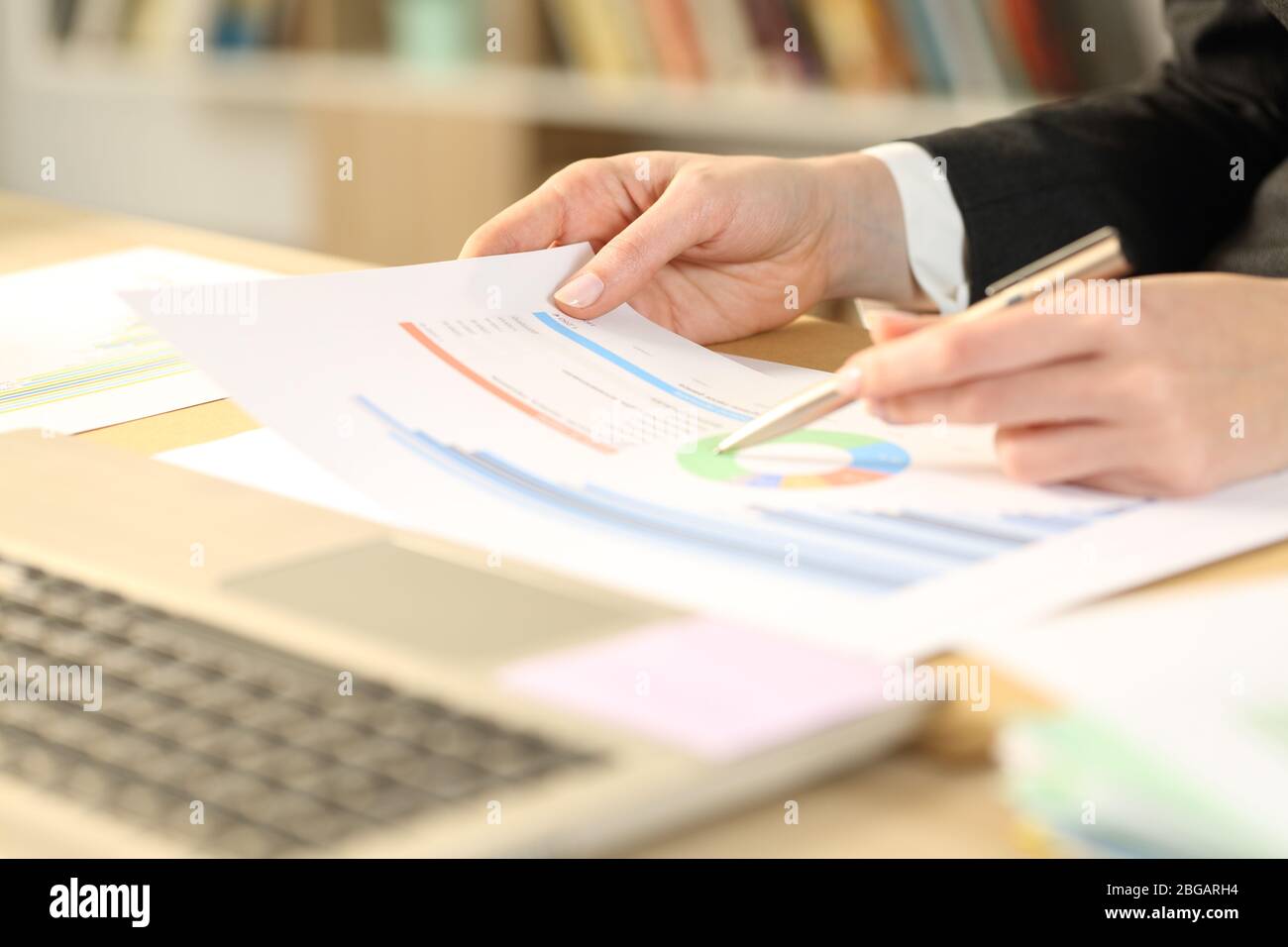 Primer plano de la mujer emprendedora manos ckecking informe de crecimiento gráfico en un escritorio en la oficina doméstica Foto de stock