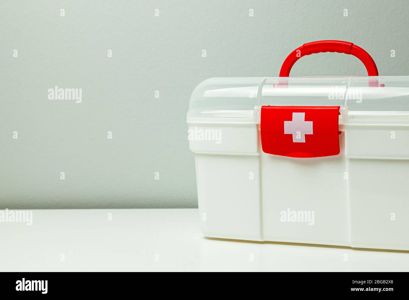 Botiquín de primeros auxilios. Caja blanca con una cruz y un broche de  color rojo sobre un fondo gris Fotografía de stock - Alamy