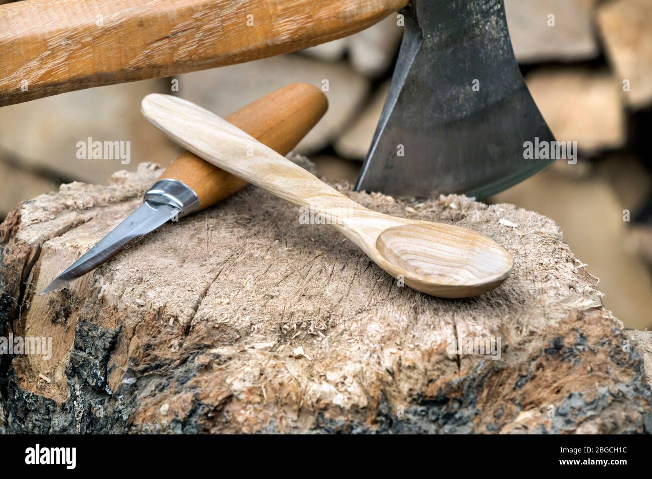 Madera de cerezo tallada a mano, cuchara en una manzana con Axe y cuchillo, Reino Unido Foto de stock
