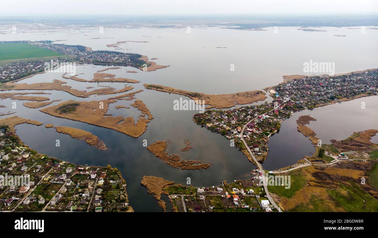 Vista de pájaro del pueblo, calles, carreteras, islas y delta del río en el horizonte. Disparo con drones. Foto de stock
