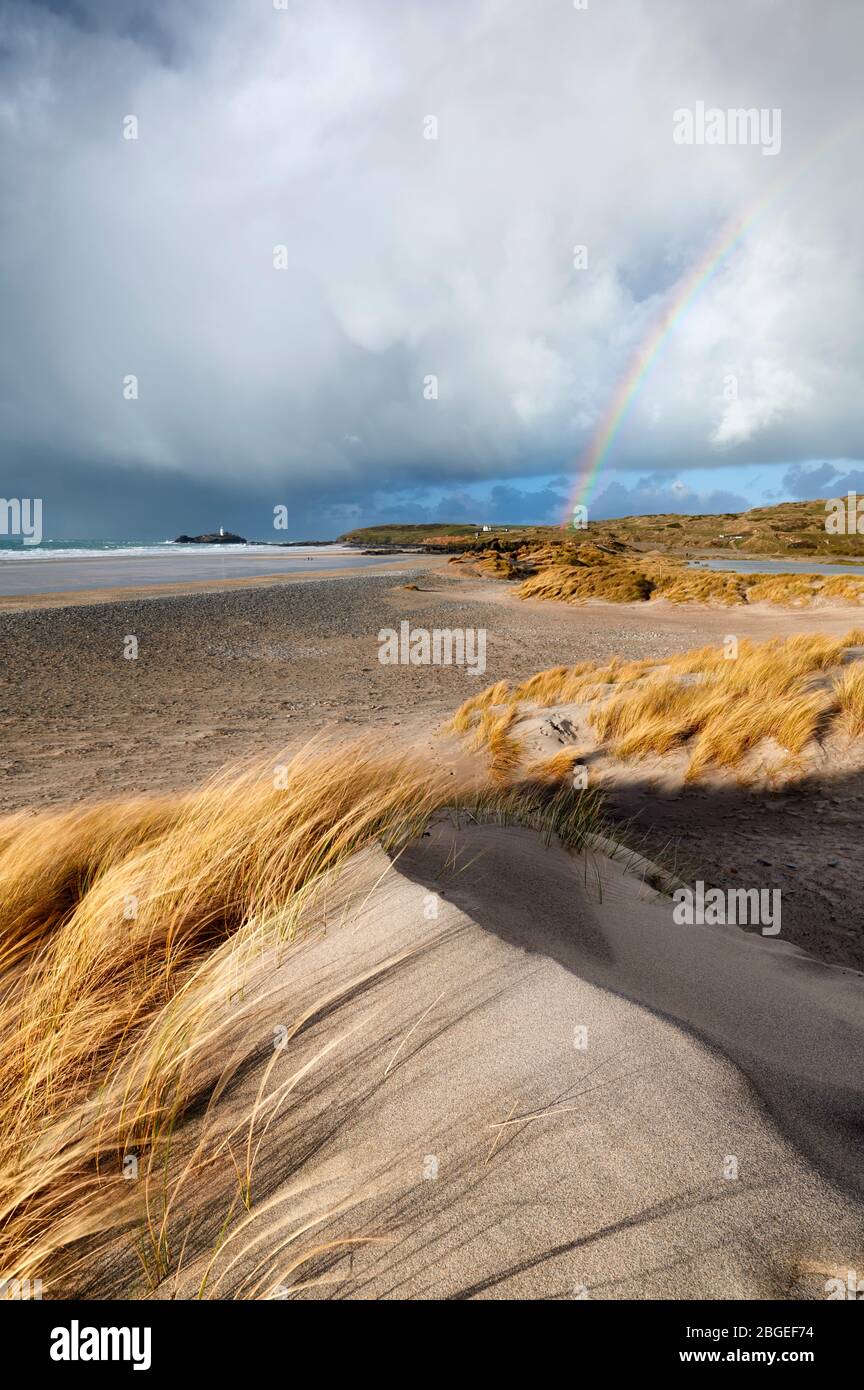 Las nubes de ducha pasan por Gwithian y Godreviy creando un arco iris Foto de stock