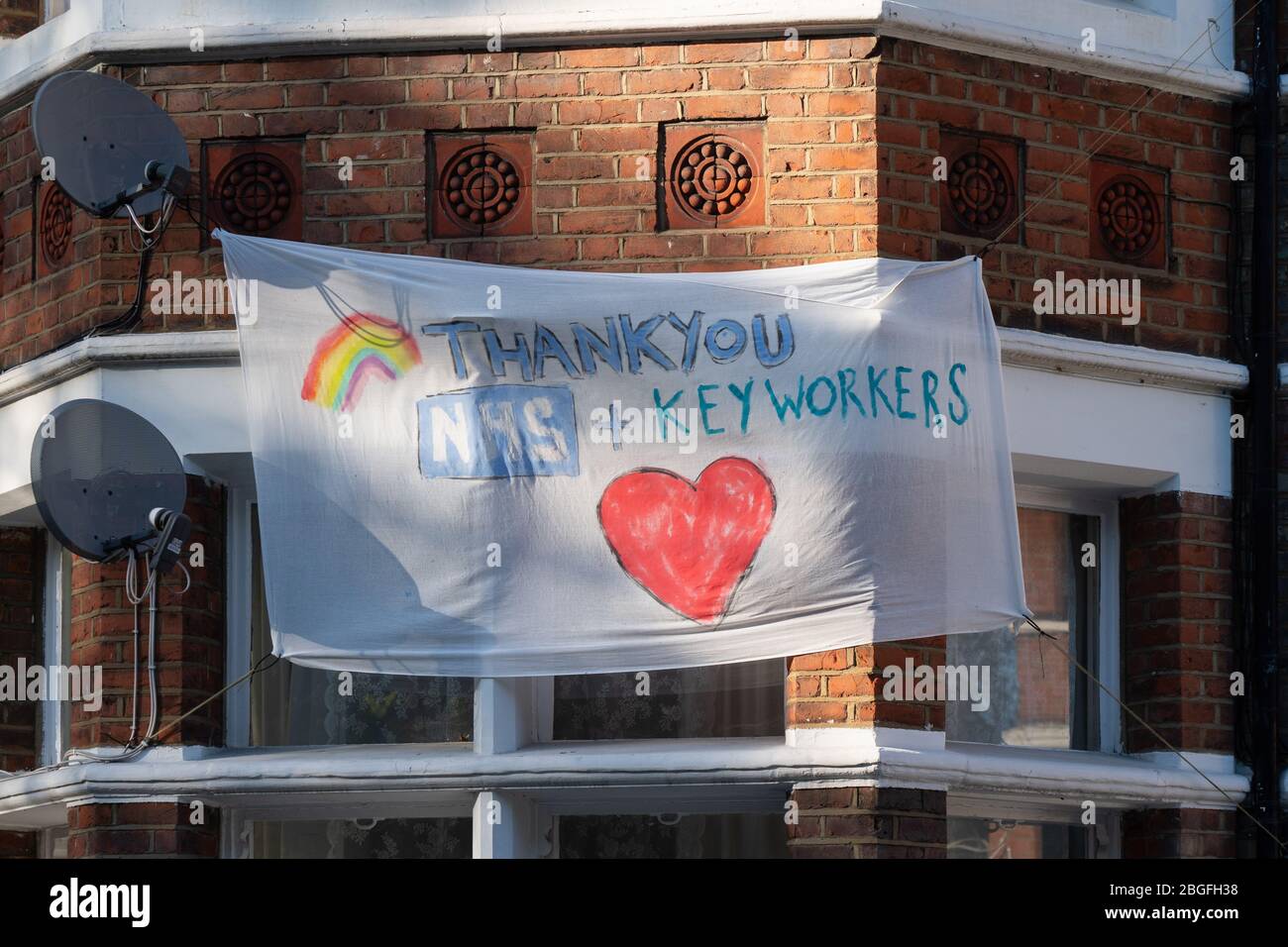 Una bandera que muestra apoyo y agradecimiento por el NHS en las ventanas de los hogares en Ealing, Londres. Fecha de la foto: Domingo, 19 de abril de 2020. Foto: Roger Garfield/A. Foto de stock