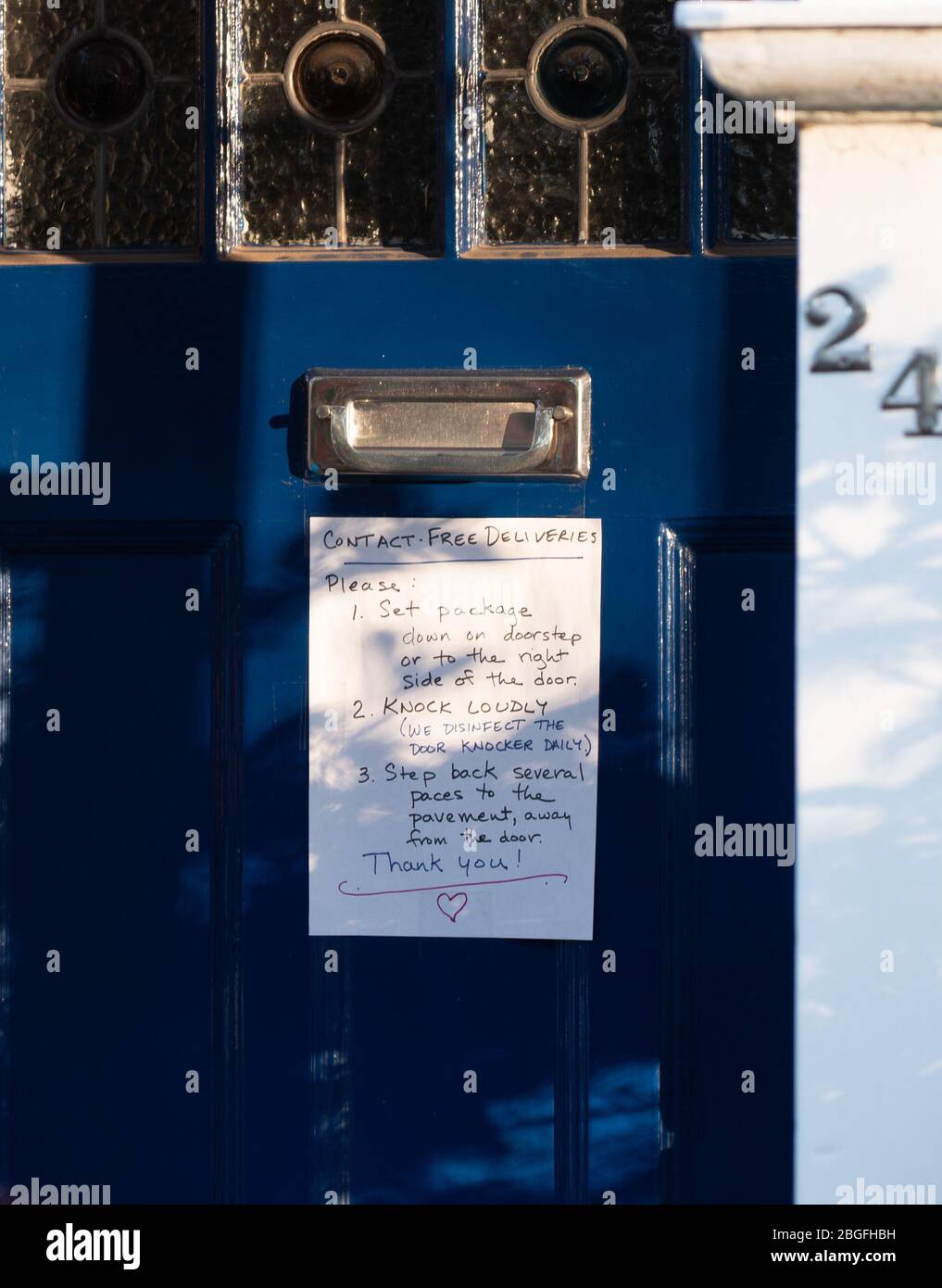 Un aviso en la puerta principal con instrucciones para entregas seguras durante la crisis de contagio de Covid-19 en Ealing, Londres. Fecha de la foto: Domingo, 19 de abril, 2 Foto de stock