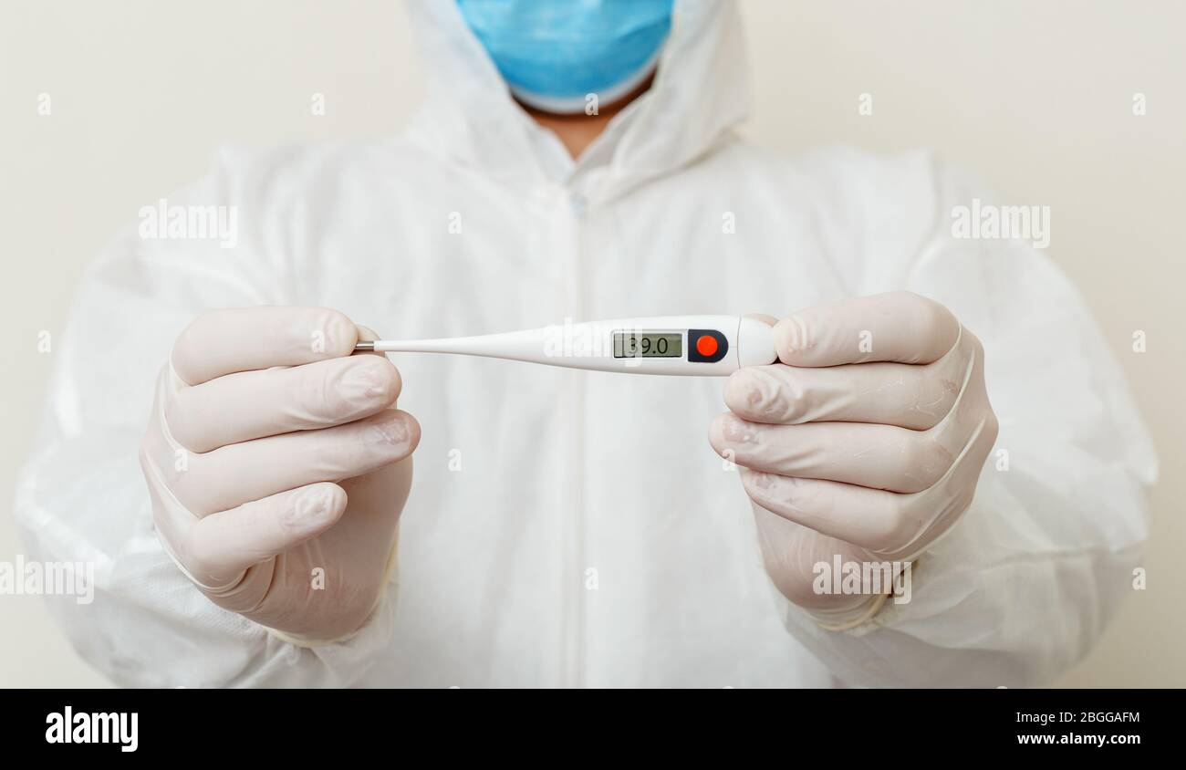 El termómetro de uso médico muestra la temperatura corporal 39.0. Covid-19,  síntomas del coronavirus. Médico que usa máscara quirúrgica protectora,  peligro biológico Fotografía de stock - Alamy