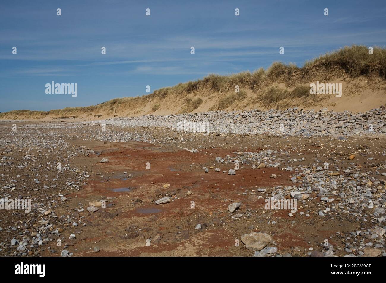 Playa de Newton con rocas férreas, guijarros y borde de dunas en la reserva natural Merthyr Mawr Foto de stock