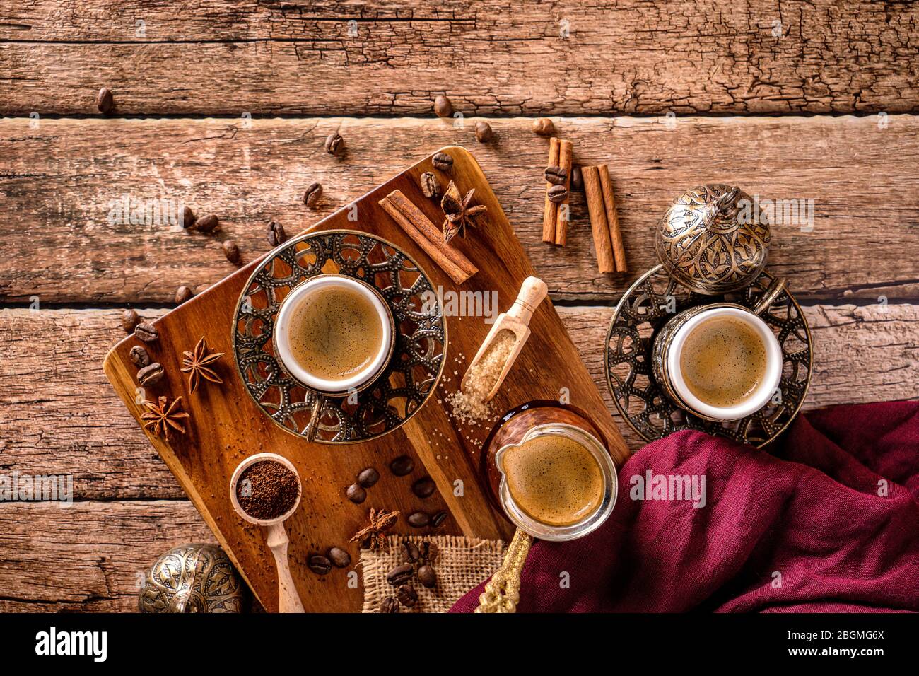 Vista superior de tazas de café, frijoles y especias en una mesa de café de madera Foto de stock