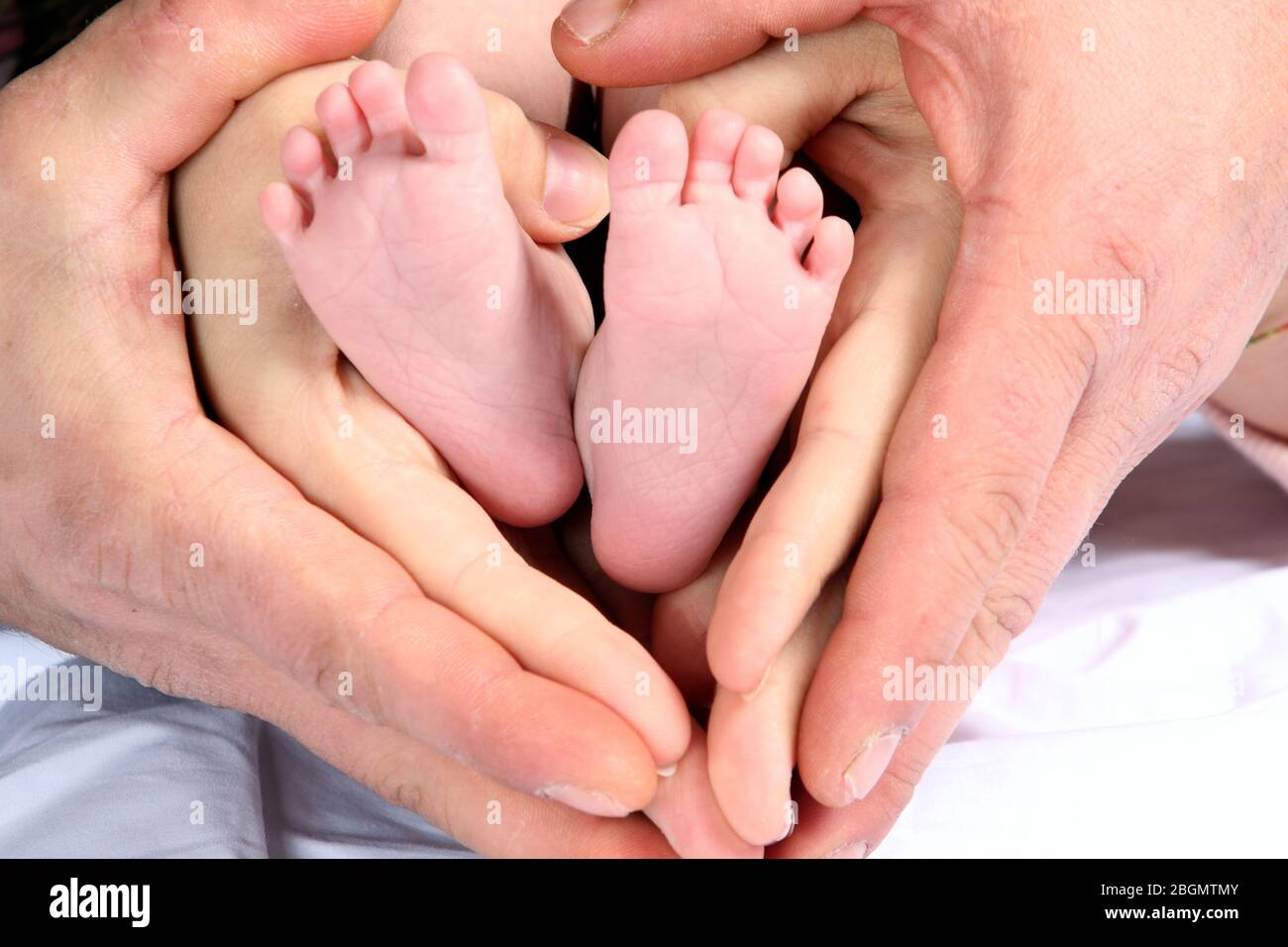 Las Manos De Mama Y Papa Formando Un Corazon En Los Pies Del Bebe Haciendose Padres Concepto Maternidad Paternidad Crianza Fotografia De Stock Alamy
