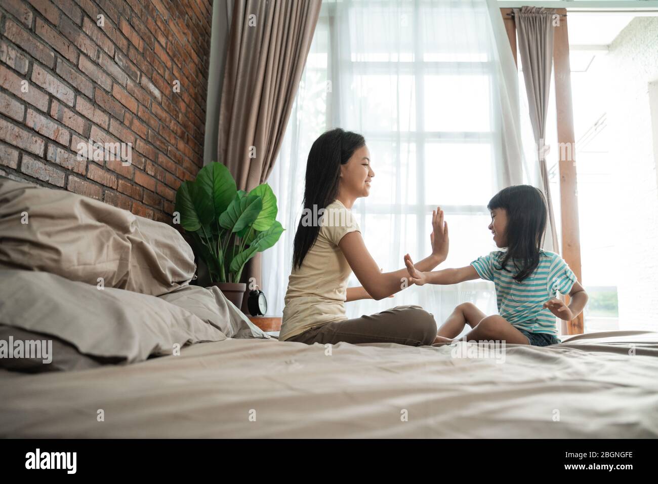 Hermanastro Y Hermanastra Juega Un Nuevo Juego la hermana del hermano juega juntos en la cama en casa Fotografía de stock  - Alamy