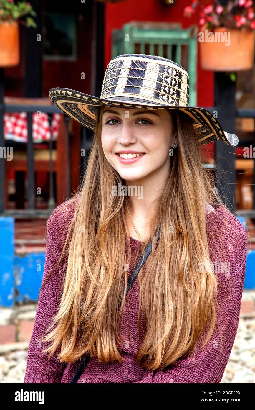 Niña joven con un sombrero vueltiao, (español colombiano para sombrero convertido) un sombrero tradicional colombiano, fuera de una tradicional finca colombiana Foto de stock