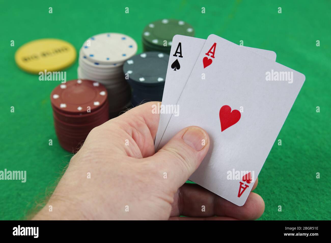 Mano sosteniendo un par de ases con fichas de casino en el fondo Texas holdem poker mejor bolsillo cohetes american Airlines Foto de stock