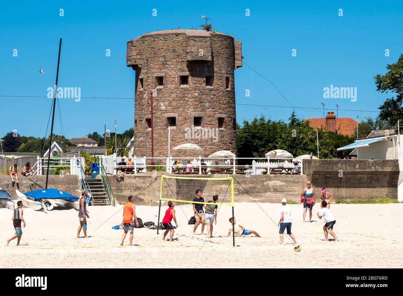 Jóvenes jugando a juegos de pelota en la playa de arena de St Aubin, Jersey, Channel las isla Foto de stock