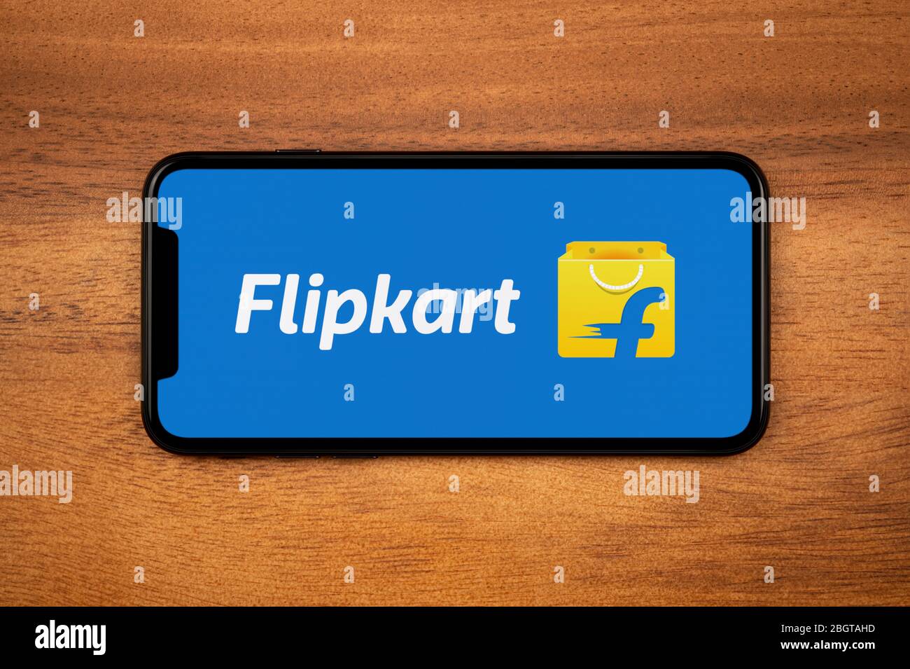 Un smartphone que muestra el logotipo de Flipkart descansa sobre una mesa  de madera plana (sólo para uso editorial Fotografía de stock - Alamy
