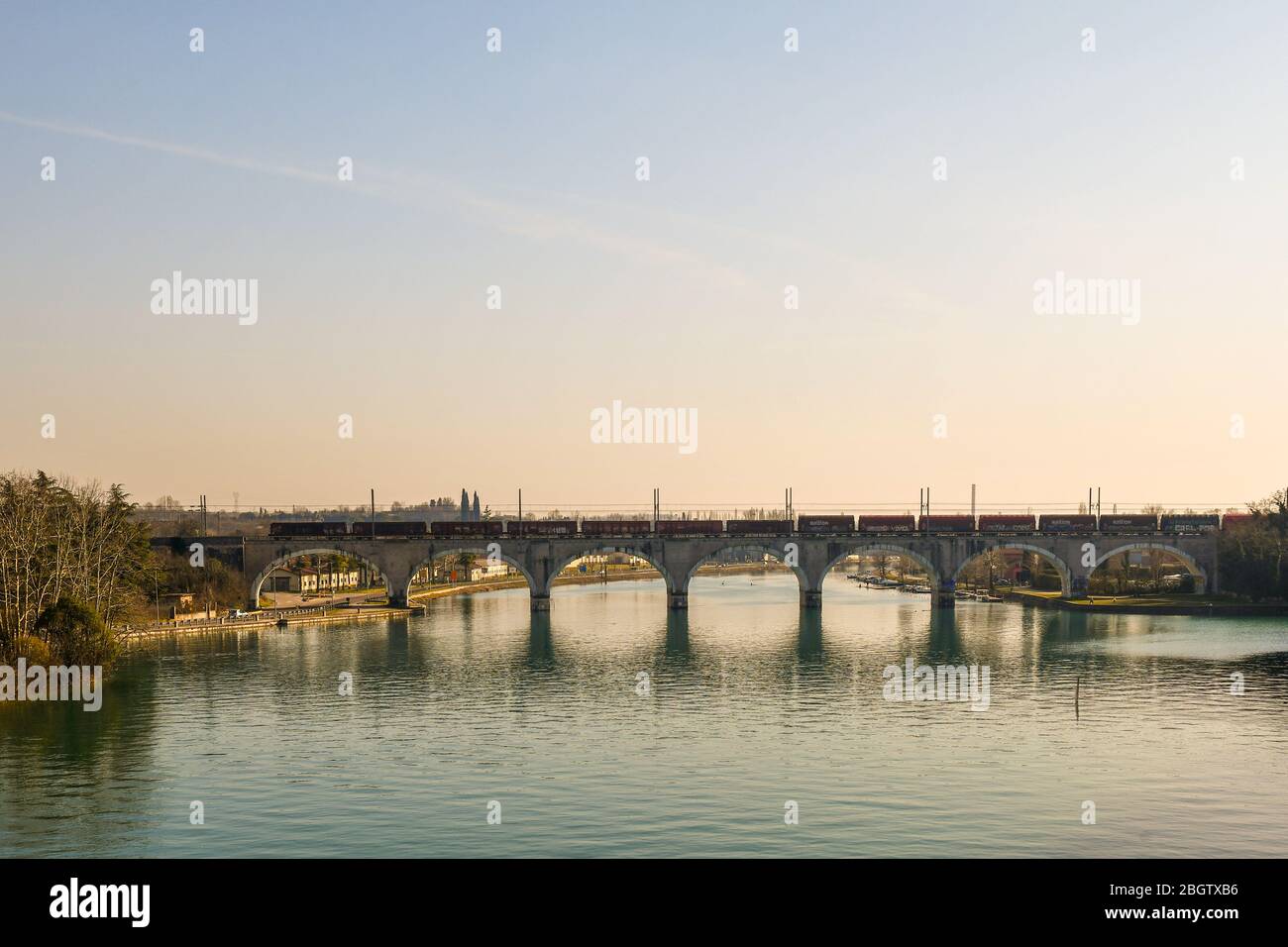 Vista panorámica del puente arqueado del ferrocarril sobre el río Mincio en Peschiera del Garda, un casco antiguo a orillas del lago Garda, Verona, Veneto, Italia Foto de stock