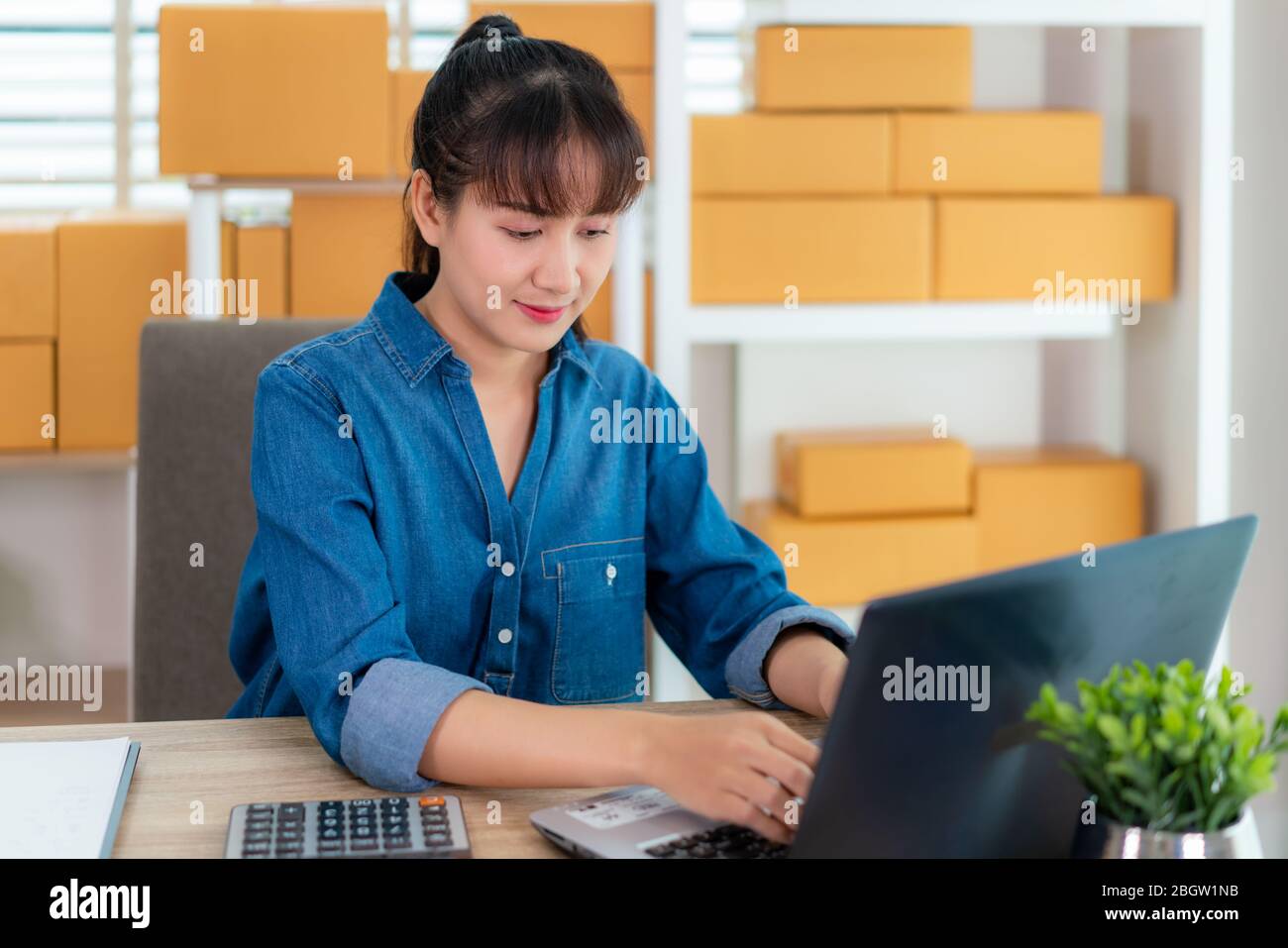 Asia propietario de la mujer de negocios trabajar en casa para las compras en línea, chat con el cliente su portátil con equipo de oficina, el estilo de vida empresarial Foto de stock