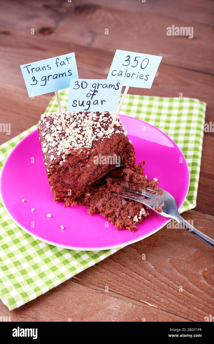 Pastel de chocolate con etiquetas de recuento de calorías y tenedor en  plato de color y servilleta, sobre fondo de mesa de madera Fotografía de  stock - Alamy