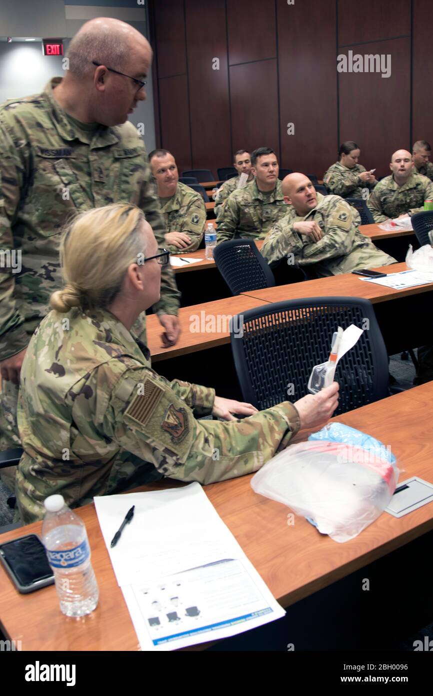 Los miembros de la Guardia Nacional de Florida (FLNG) se reúnen con el personal del hospital local para colaborar en la administración de la prueba de detección COVID-19 durante la respuesta de Task Force – Medicals al virus COVID-19, 17 de marzo de 2020. El FLNG está movilizando hasta 500 ciudadanos-soldados y aviadores en apoyo de la respuesta del Departamento de Salud de Florida en el Condado de Broward. (EE.UU Foto del ejército por Sgt. Leia Tascarini) Foto de stock