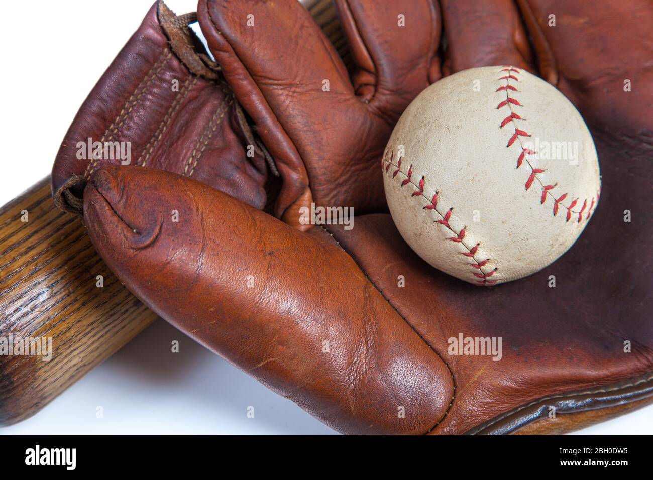 Un primer plano de un guante de béisbol de cuero, bola un murciélago de madera Foto de stock