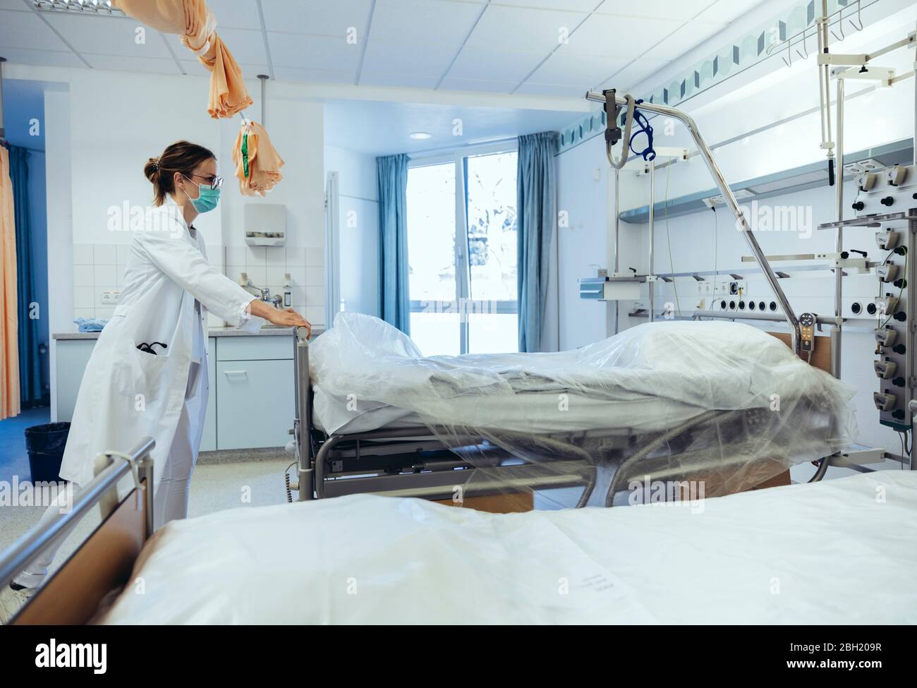 Médico en la habitación del hospital empujando camas Fotografía de stock -  Alamy