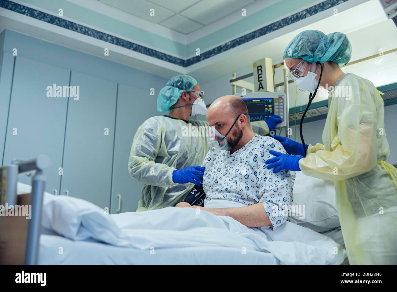 Médicos que dan respiración artificial al paciente en la unidad de cuidados de urgencias de un hospital Foto de stock