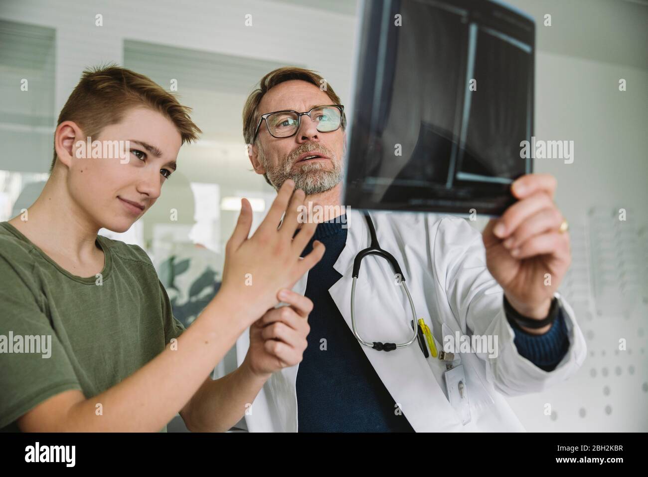 El médico le explica al adolescente en la práctica médica Foto de stock