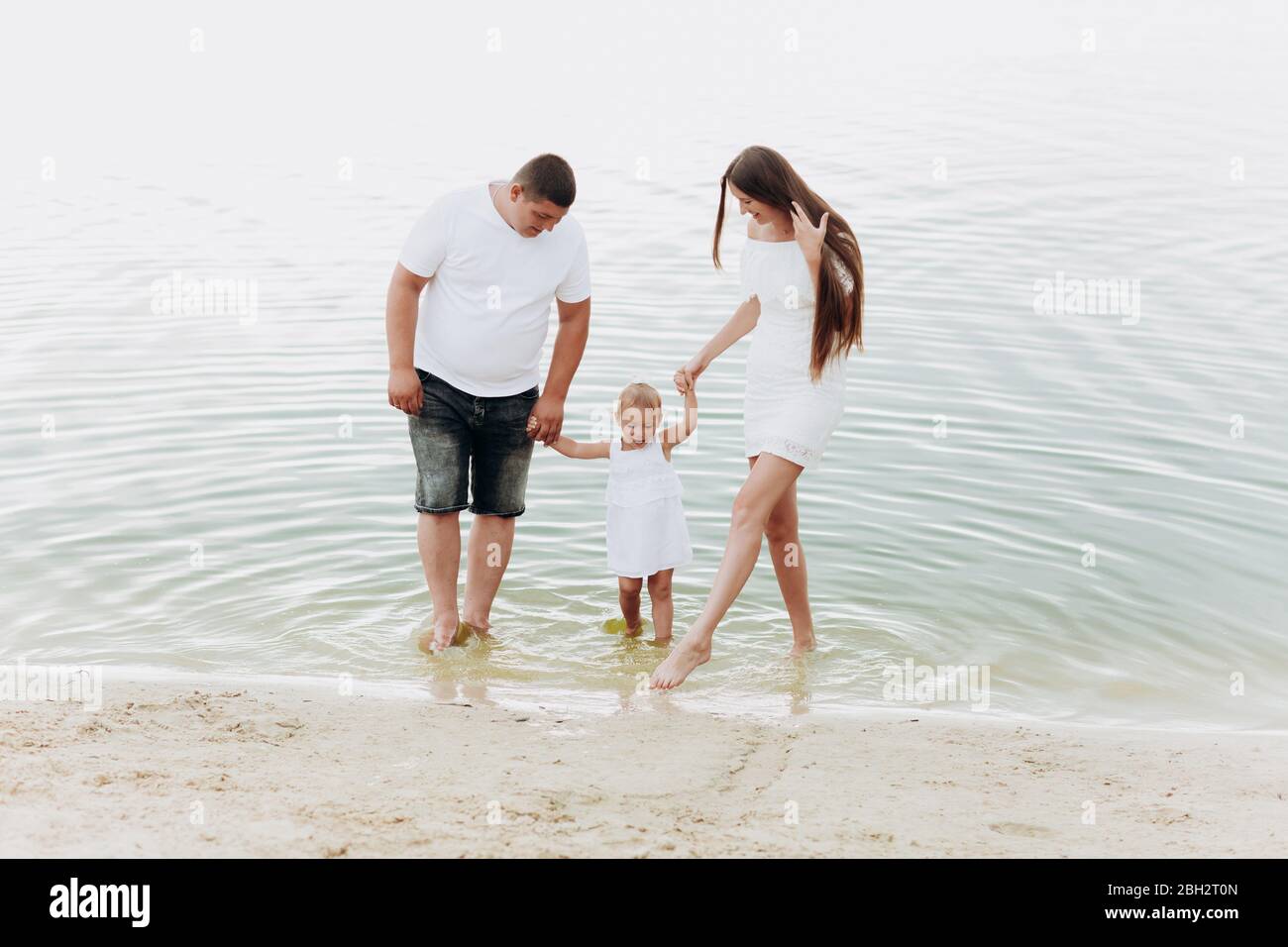Mama Papa Una Hija Que Se Estaba Acercada Caminando Por La Playa Cerca Del Lago El Concepto De Vacaciones De Verano Dia De La Madre Del Padre Del Bebe Familia Pasando Tiempo