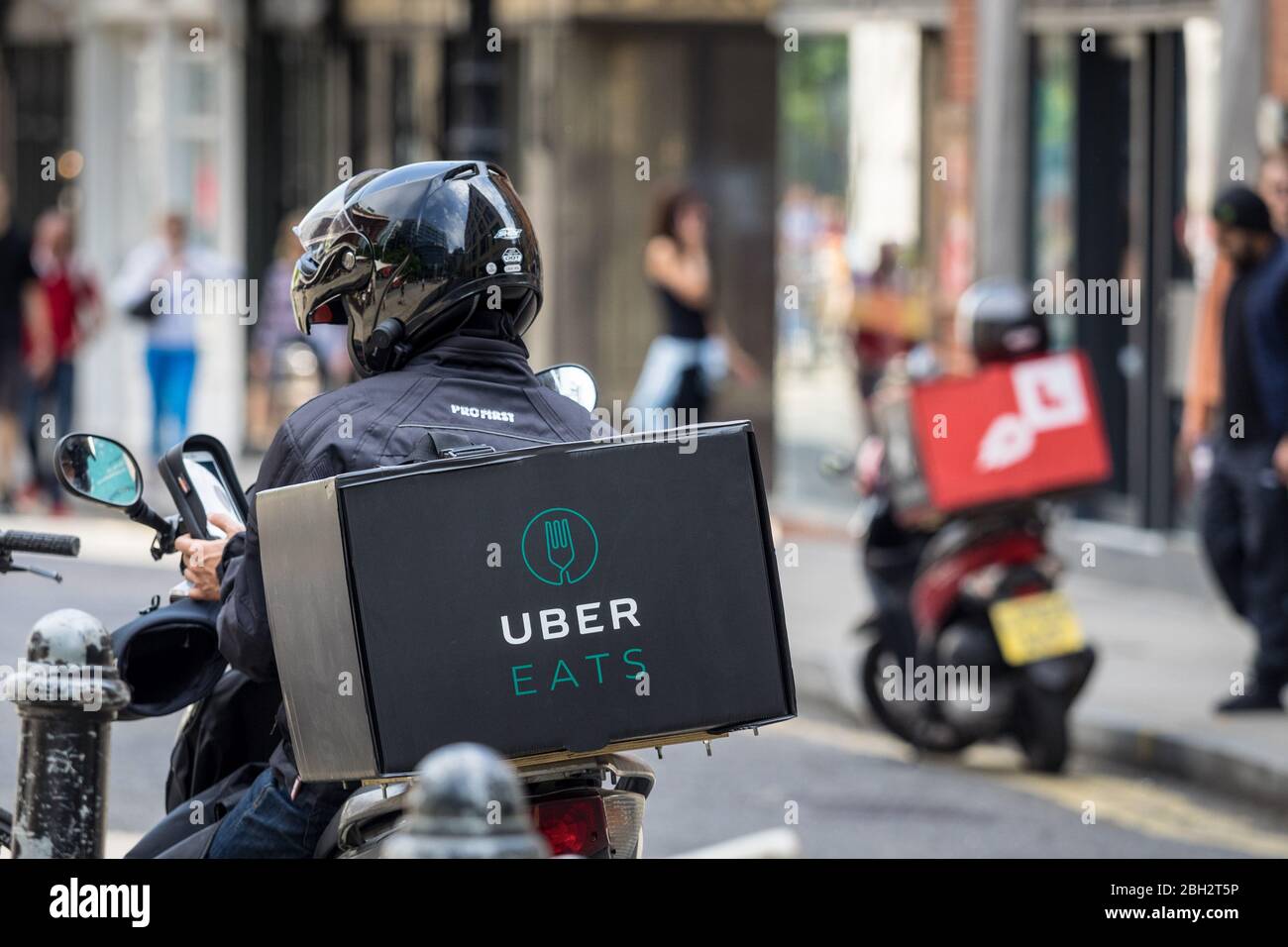 Uber Eats mensajería de entrega de comida. Scooter Uber Eats. Uber Easts Food Courier Londres. Foto de stock