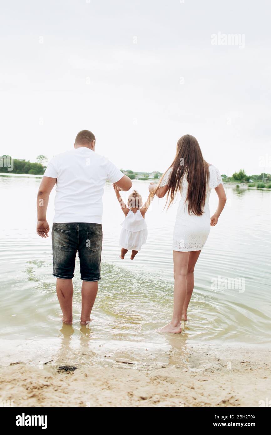 Mama Papa Una Hija Que Se Estaba Acercada Caminando Por La Playa Cerca Del Lago El Concepto De Vacaciones De Verano Dia De La Madre Del Padre Del Bebe Familia Pasando Tiempo