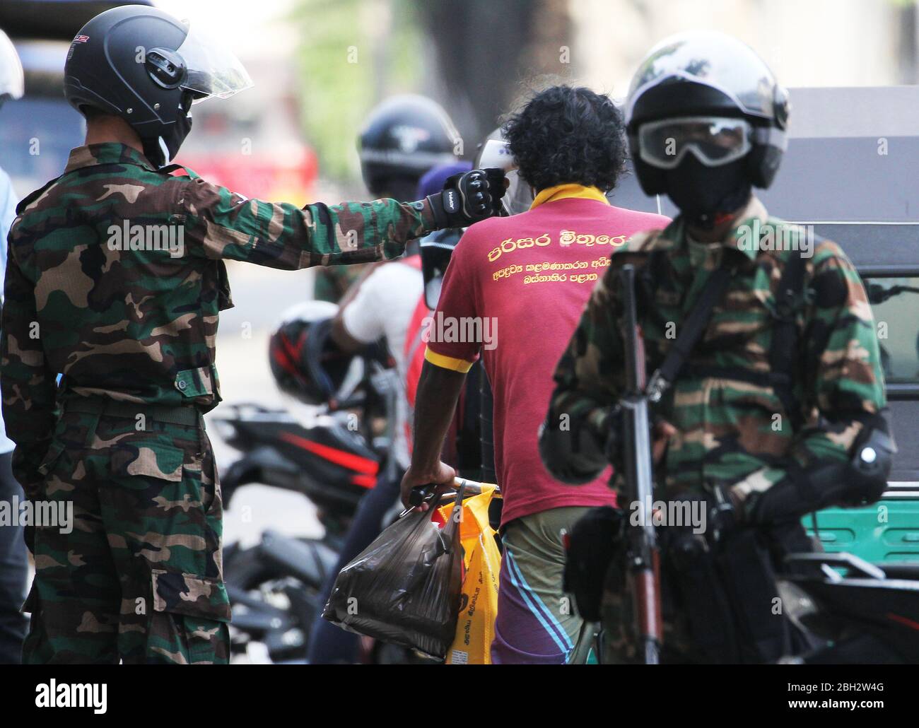 Colombo, provincia occidental, Sri Lanka. 23 de abril de 2020. Un personal del ejército de sri Lanka controla la temperatura corporal en un puesto de control en Colombo el 23 de abril de 2020. Crédito: Pradeep Dambarage/ZUMA Wire/Alamy Live News Foto de stock