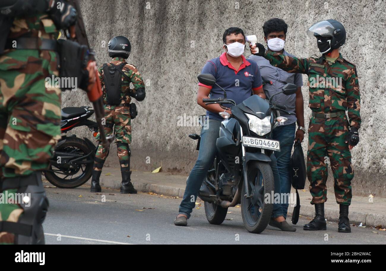 Colombo, Sri Lanka. 23 de abril de 2020. Un personal del ejército de sri Lanka controla la temperatura corporal en un puesto de control en Colombo el 23 de abril de 2020. (Foto de Saman Abesiriwardana/Pacific Press) crédito: Pacific Press Agency/Alamy Live News Foto de stock