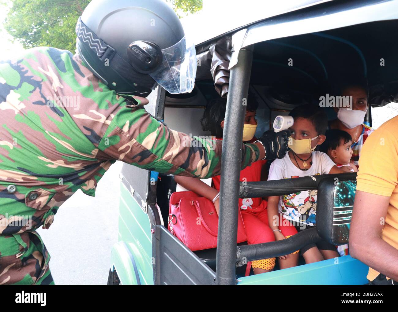 Colombo, Sri Lanka. 23 de abril de 2020. Un personal del ejército de sri Lanka controla la temperatura corporal en un puesto de control en Colombo el 23 de abril de 2020. (Foto de Saman Abesiriwardana/Pacific Press) crédito: Pacific Press Agency/Alamy Live News Foto de stock