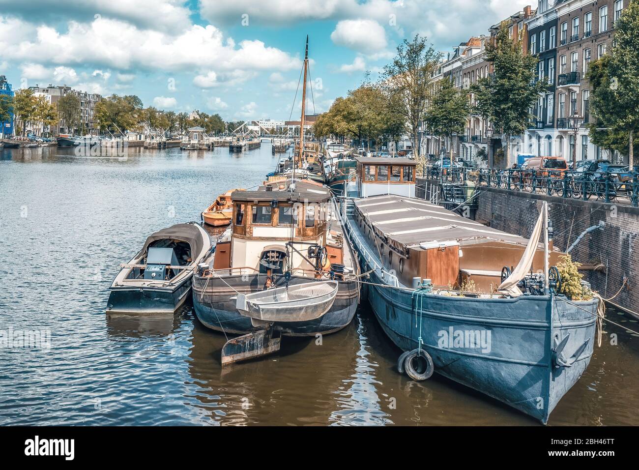 El barco holandés en el canal está atracado junto a un cuerpo de agua Foto de stock