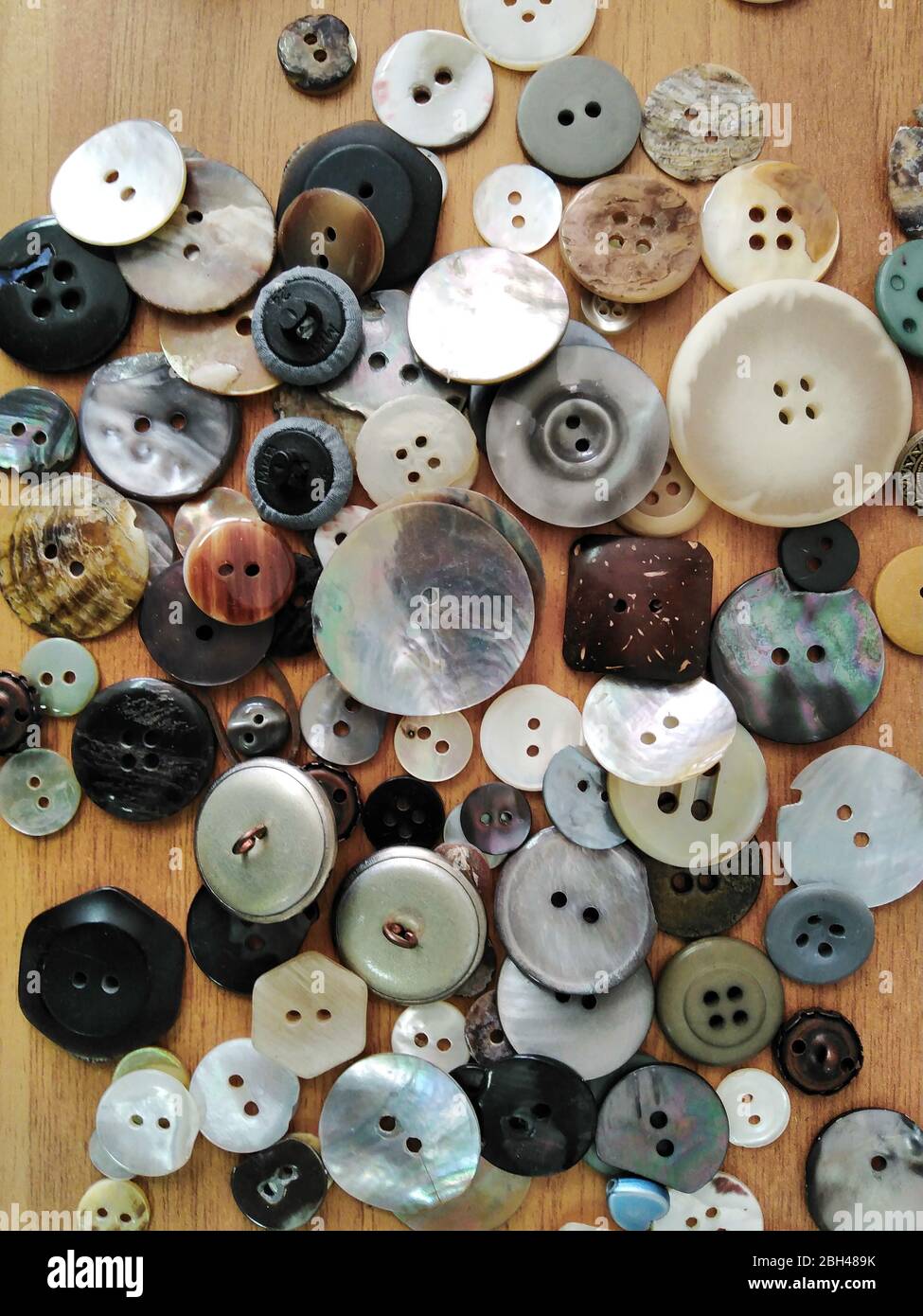 Variedad de botones de ropa primer plano sobre la superficie de la mesa Foto de stock