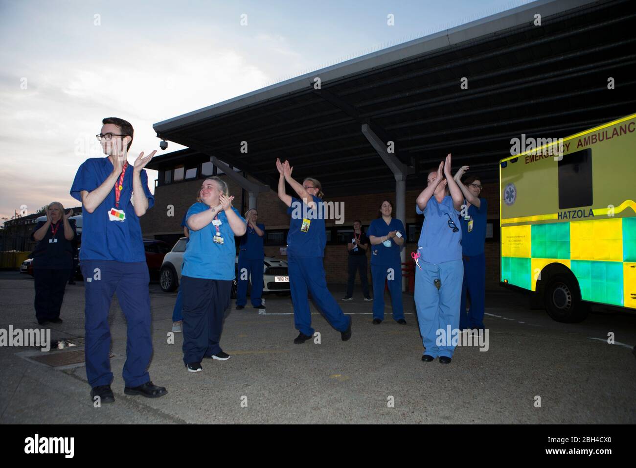 Londres, Reino Unido. 23 de abril de 2020. El personal del hospital sale de Homerton University Hospital Foundation Trust en el este de Londres y es recibido por una pequeña multitud. Aplaudir a los cuidadores, para decir gracias a NHS y otros trabajadores y cuidadores clave. El "bloqueo" continúa en Hackney debido al brote de COVID-19. Crédito: Marcin Nowak/Alamy Live News Foto de stock