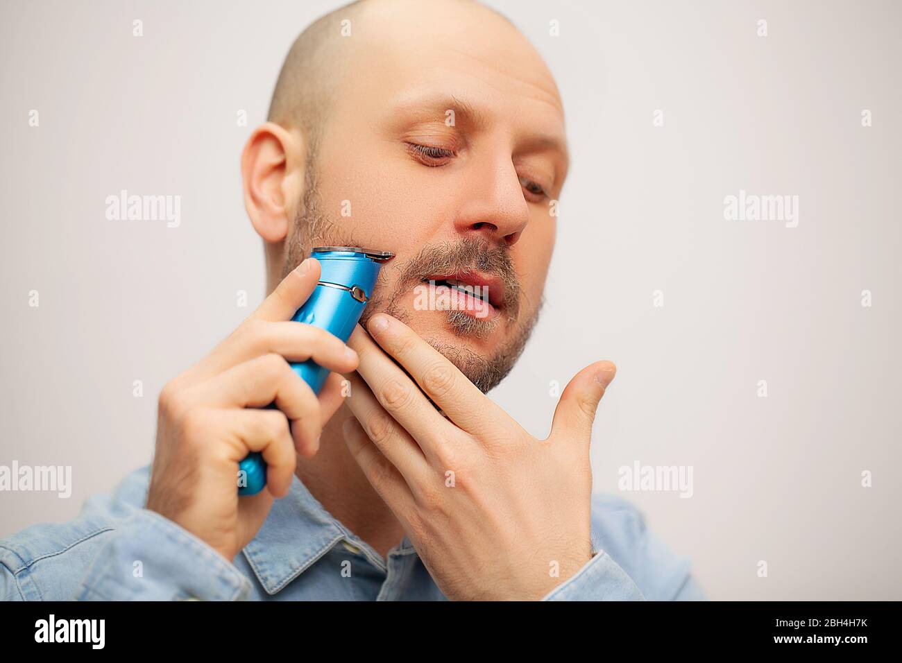 Hombre recorta su barba con una máquina de escribir eléctrica