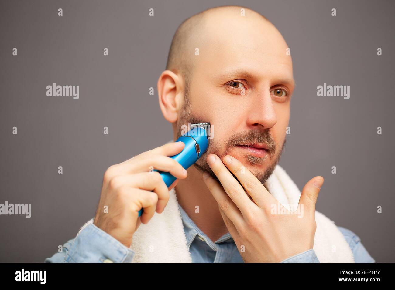 El hombre recorta su barba con una máquina de escribir eléctrica