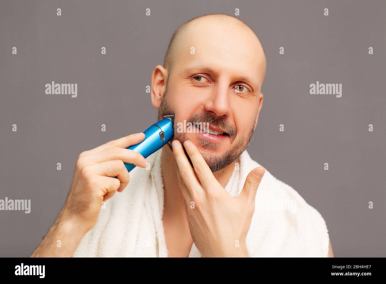 Hombre recorta su barba con una máquina de escribir eléctrica