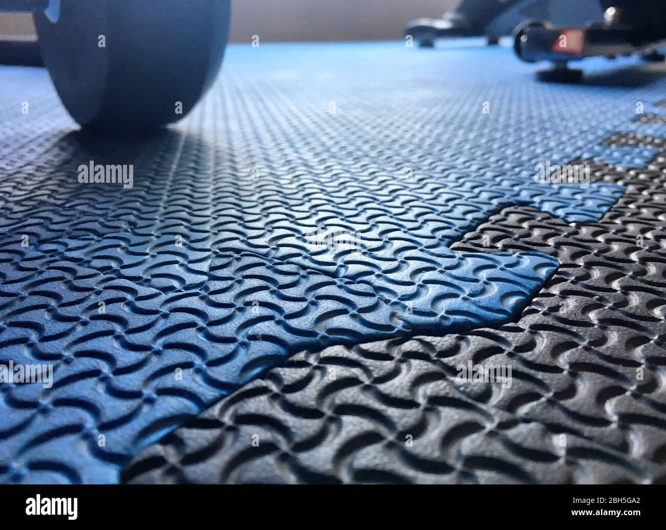La foto del suelo de goma azul del gimnasio con la sombra de un mancuerno  detrás Fotografía de stock - Alamy