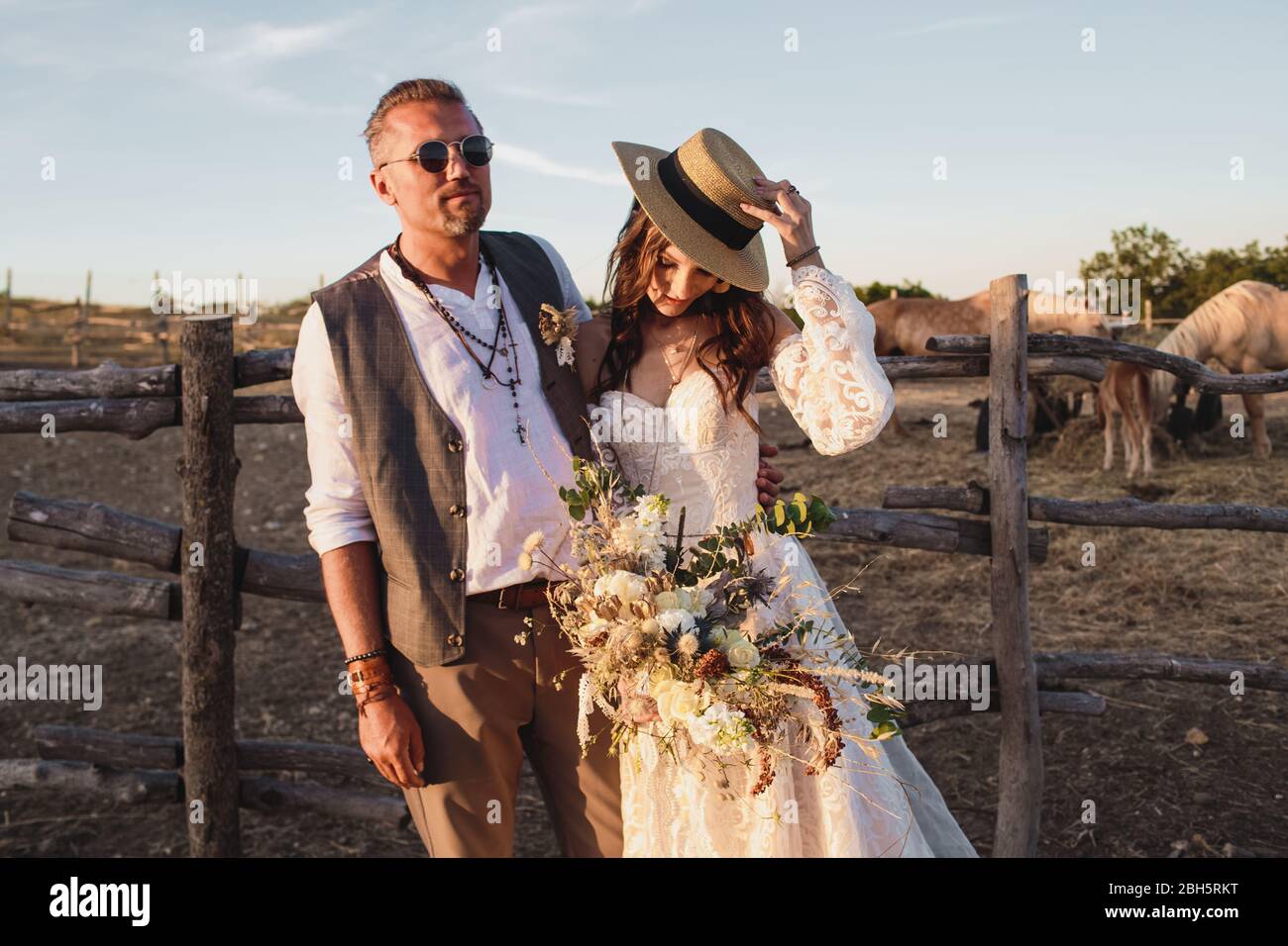 Pareja de bodas en el estilo boho en el rancho. Ramo de boda de diseño  Fotografía de stock - Alamy